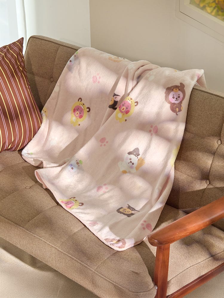 BT21 BABY MORE FLUFFY BLANKET sur un canapé beige, couverture bébé kawaii aux personnages LINE FRIENDS.