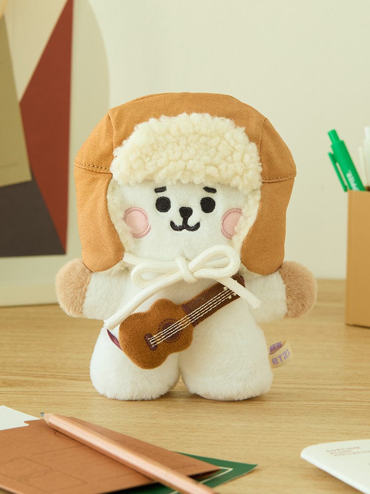 BT21 CAMPFIRE CLOSET - WINTER HAT, peluche BT21 LINE FRIENDS en chapeau d’hiver, sur bureau avec fournitures.