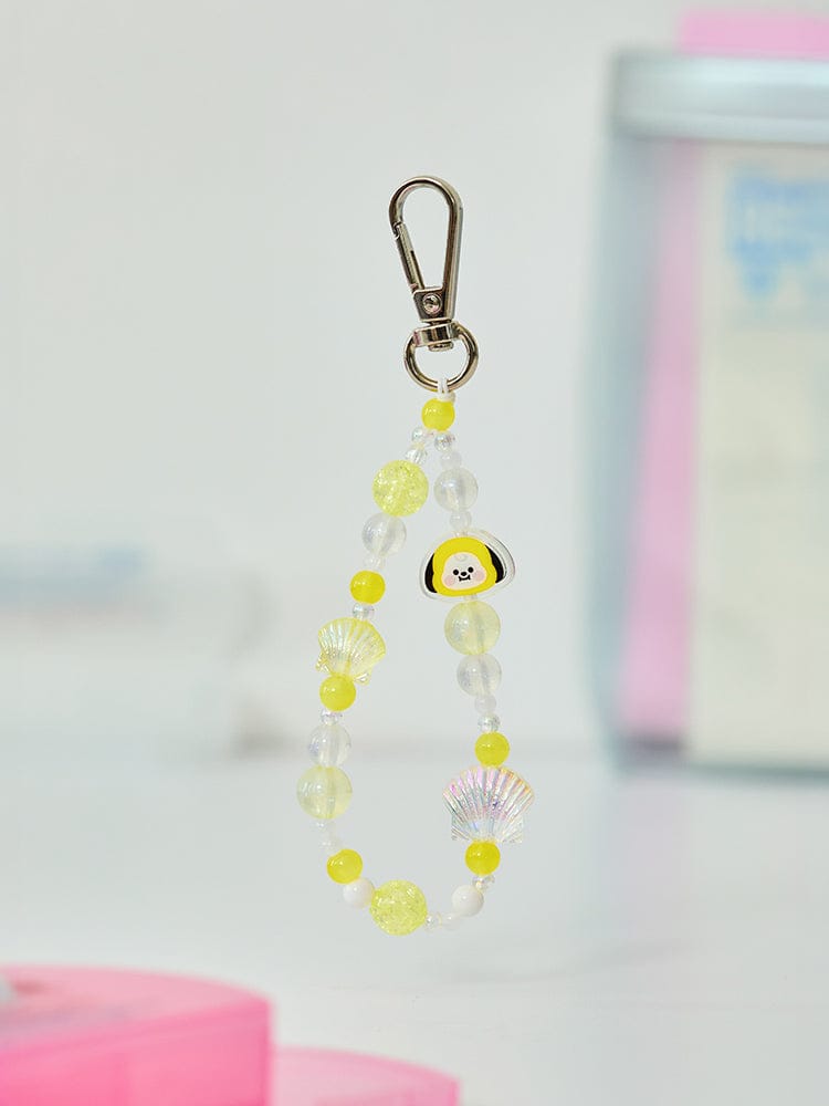 BT21 CHIMMY BABY PEARL BEADED KEYRING LINE FRIENDS : porte-clés perlé jaune avec CHIMMY sur fond pastel, près d’un livre