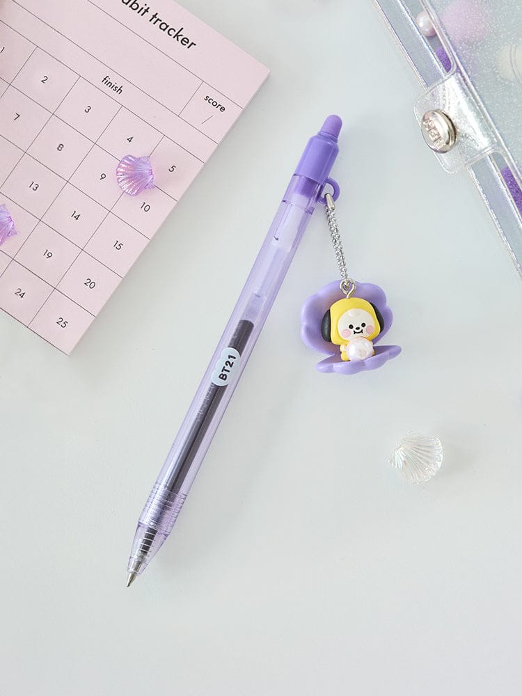 BT21 CHIMMY BABY PEARL FIGURINE GEL PEN de LINE FRIENDS, stylo violet avec figurine sur bureau et bloc-notes.