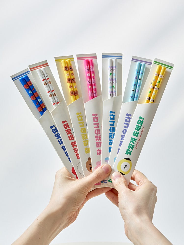 BT21 CHOPSTICKS SOUVENIR officiels LINE FRIENDS : mains tenant des baguettes kawaii, personnages BT21 sur fond clair.