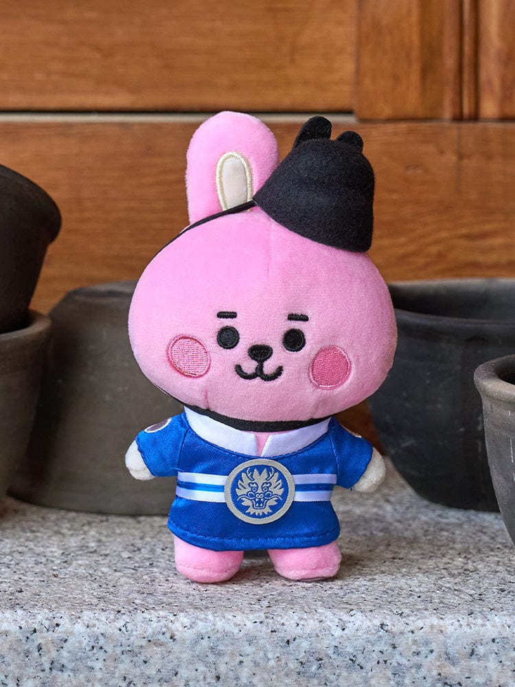 BT21 COOKY BABY PLUSH DOLL K-EDITION 2 : peluche officielle COOKY lapin musclé, sur sol près d’un salon, style mignon
