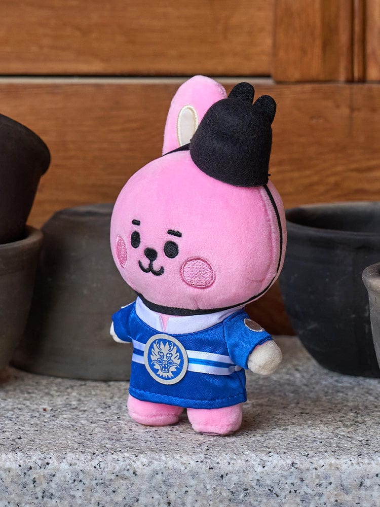 BT21 COOKY BABY PLUSH DOLL K-EDITION 2 : peluche officielle COOKY en tenue bleue, posée sur sol, style chambre