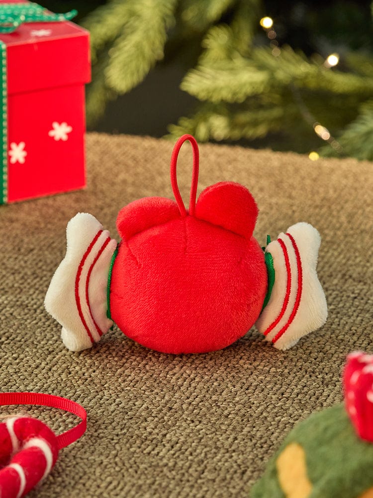 BT21 COOKY mini minini ORNAMENT PLUSH KEYRING PETITE HOLIDAY, porte-clés en peluche rouge près de cadeaux, sapin et décor festif