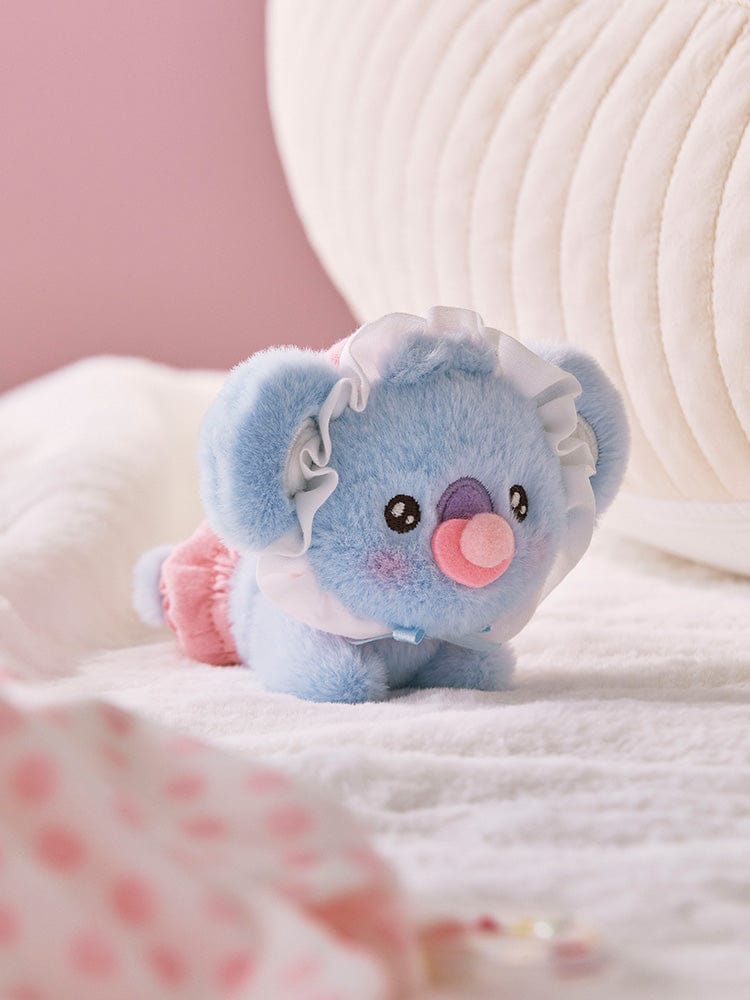 BT21 KOYA BABY PLUSH NEWBORN SEASON 2 : peluche officielle LINE, koala bleu sur lit rose, décor chambre bébé.