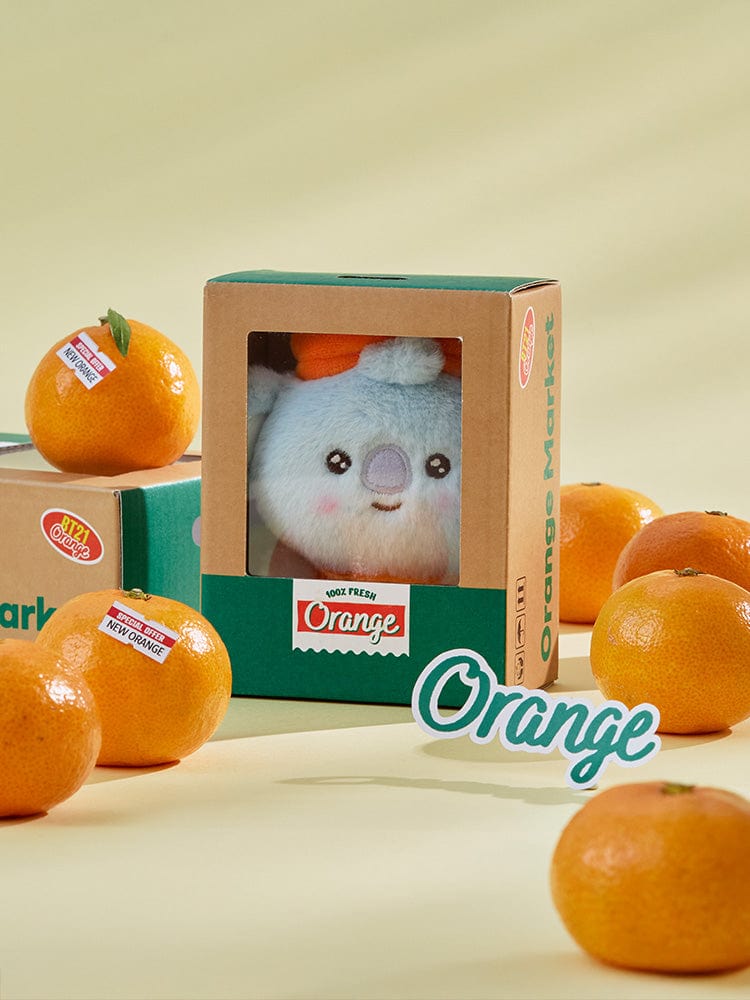 BT21 KOYA BABY PLUSH ORANGE PARTY : peluche KOYA orange LINE, en boîte cadeau, sur fond beige, ambiance fête