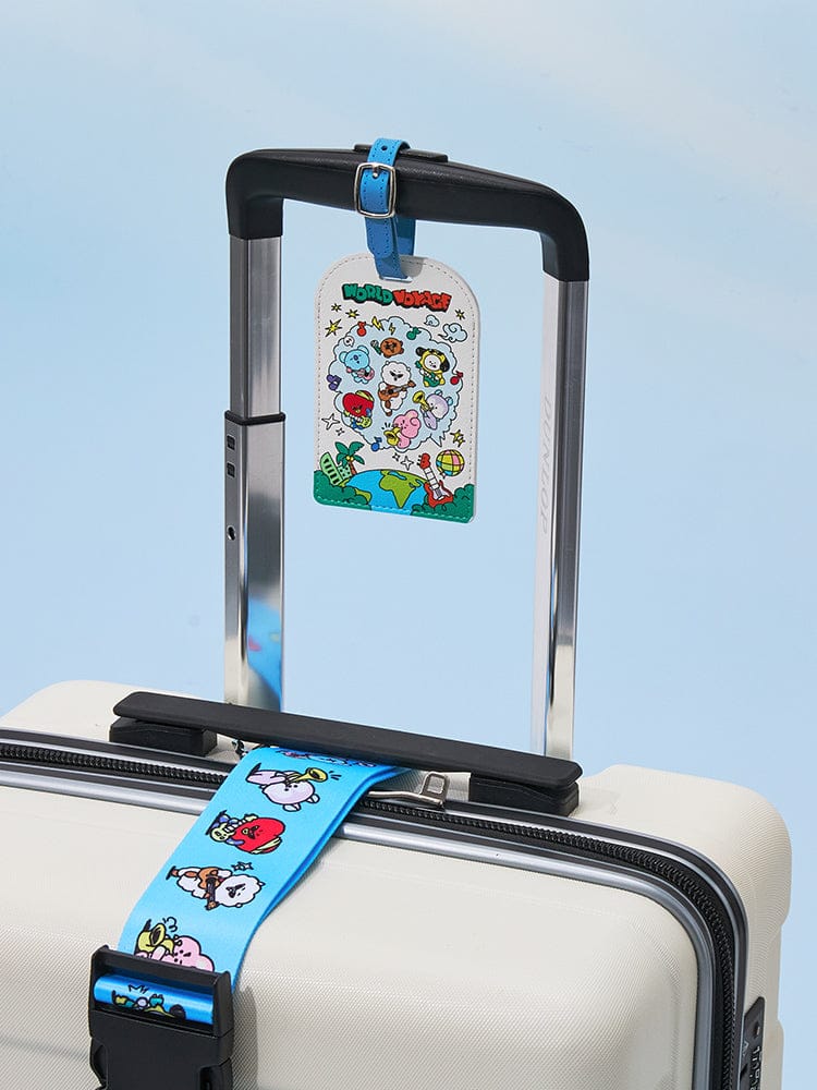 BT21 LUGGAGE TAG WORLD VOYAGE : étiquette de valise BT21 LINE FRIENDS officielle, sur bagage beige devant ciel bleu, voyage.