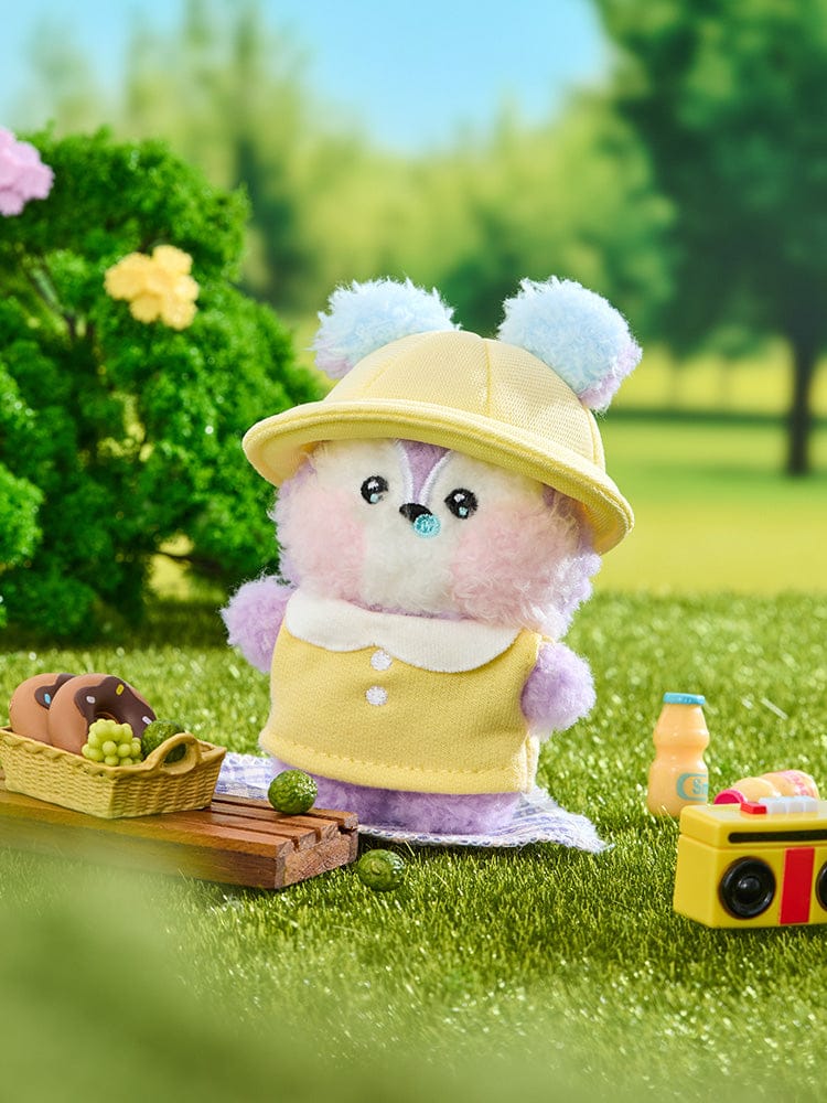 BT21 MANG mini minini PLUSH PICNIC MATE : peluche BT21 MANG sur panier pique-nique, décor herbe verte, jardin ensoleillé.