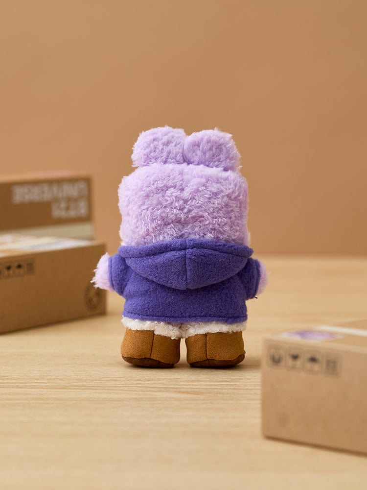 BT21 MANG minini DOLL BOOTS EDITION, peluche MANG violette sur bureau, ambiance boutique, style rond minimaliste.