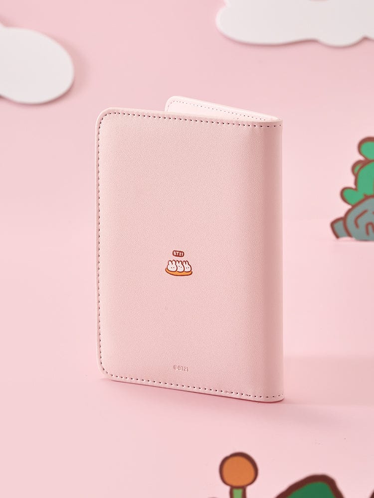 BT21 PASSPORT COVER K-TOKKI de LINE FRIENDS : pochette passeport rose avec personnage K-Tokki, sur fond pastel voyage