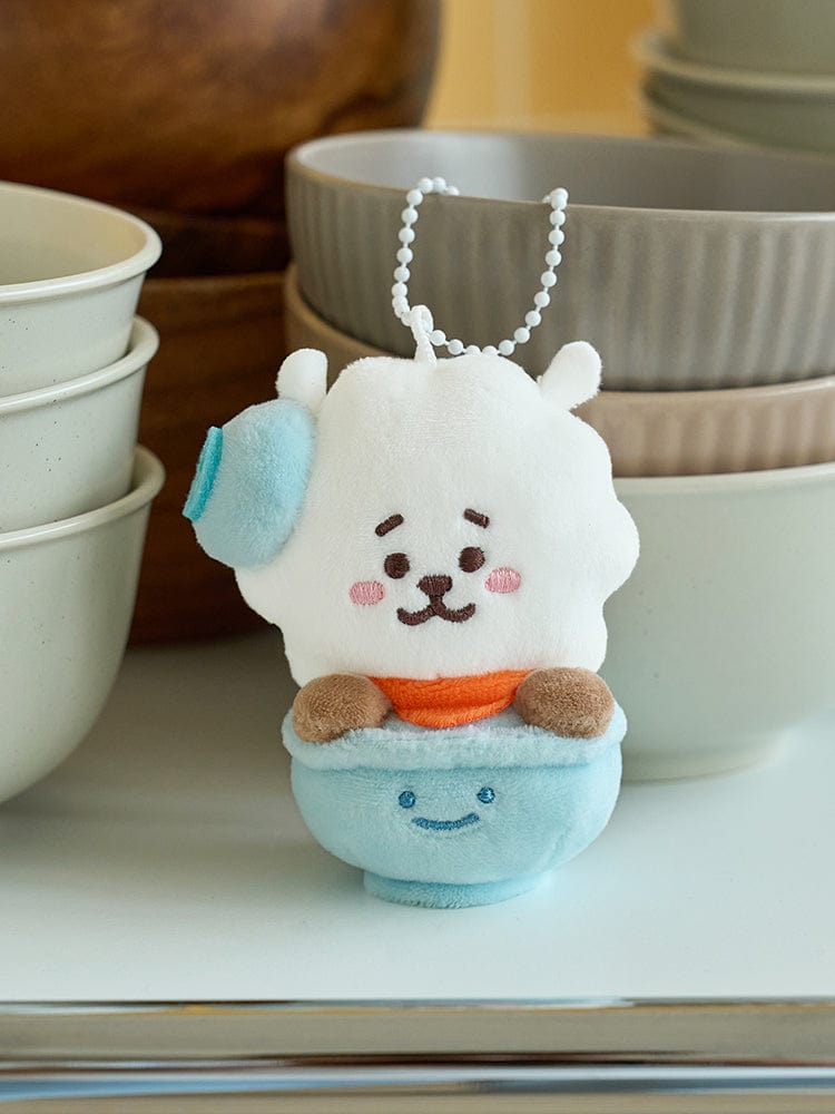 BT21 RJ WELCOME PARTY RICE BOWL DOLL KEYRING (S) LINE FRIENDS : porte-clés RJ en tête de lapin sur table, ambiance fête.