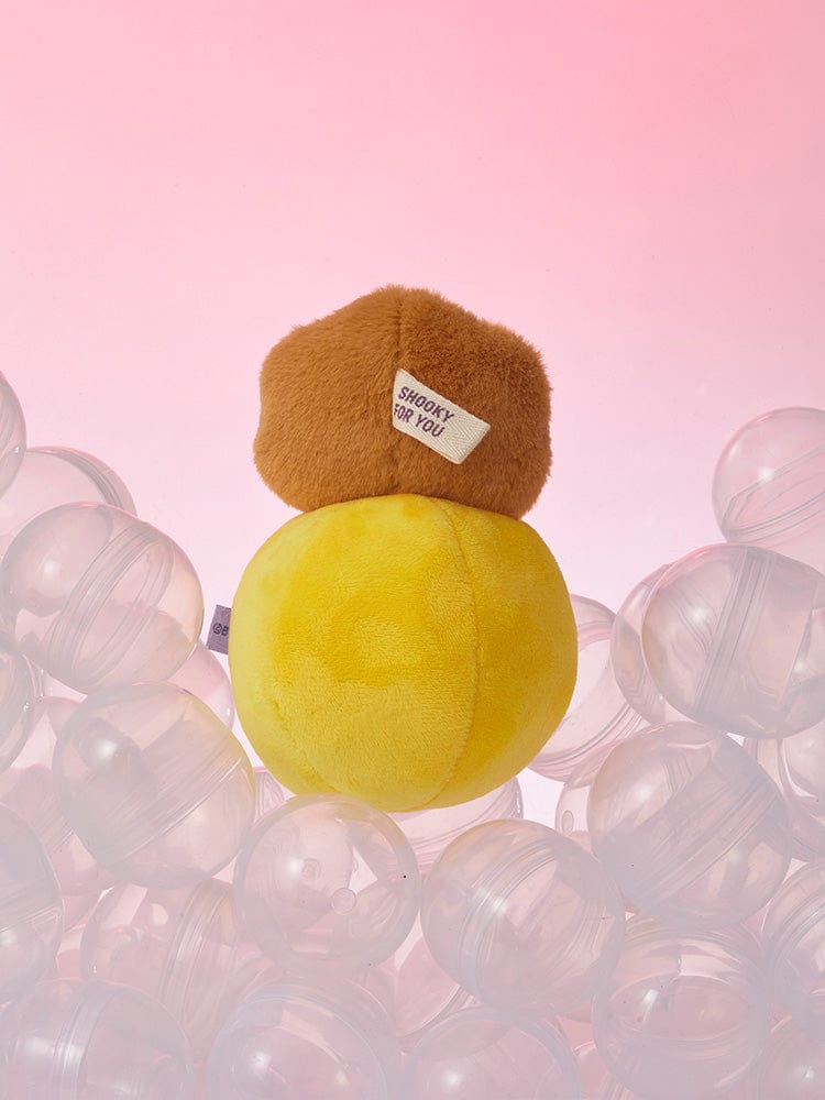 BT21 SHOOKY minini PLUSH LUCKY GATCHA : peluche SHOOKY brune et jaune sur fond rose, style gatcha collection Minini BTS.