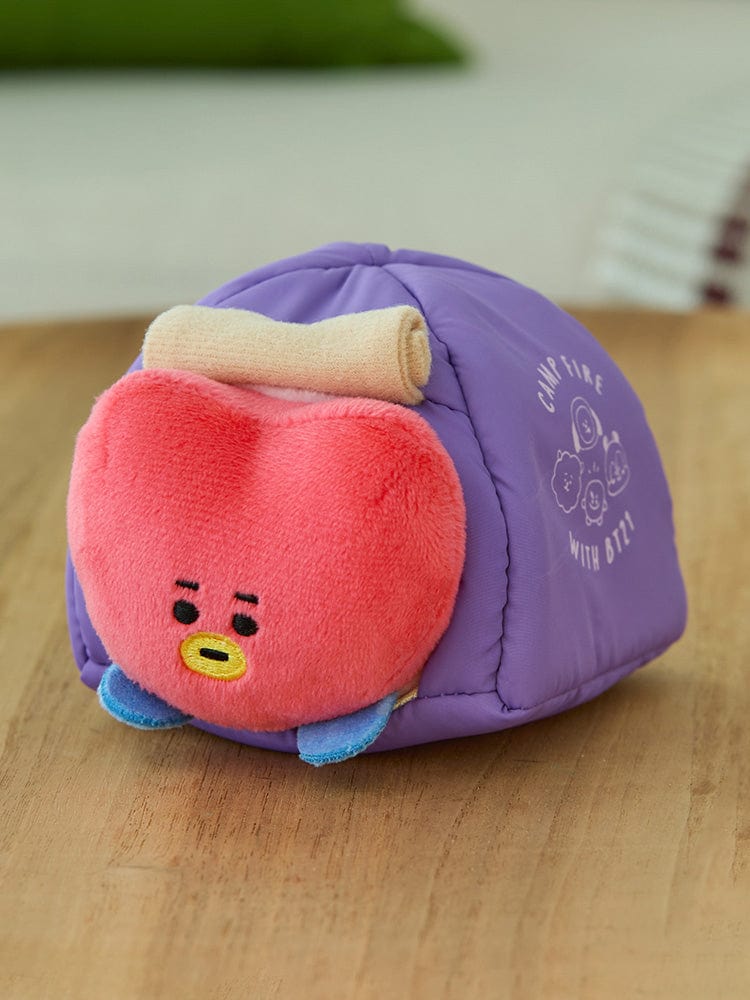 BT21 TATA DOLL CAMPFIRE, peluche officielle LINE FRIENDS : TATA violet et rouge sur table, ambiance chaleureuse.