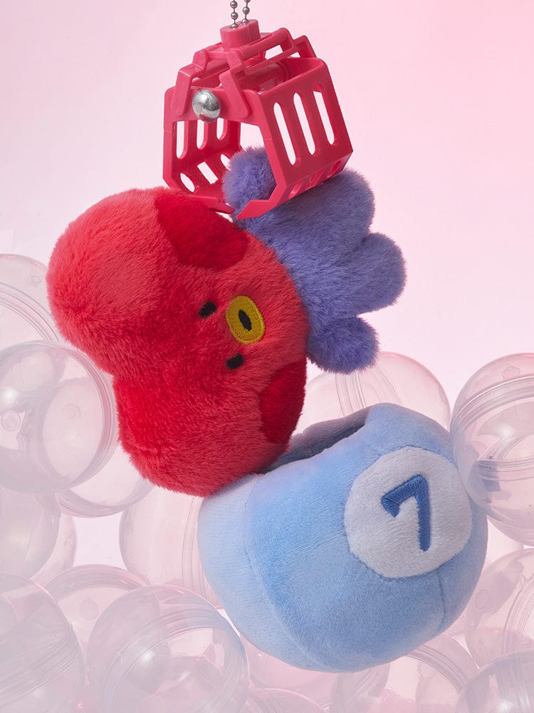 BT21 TATA minini PLUSH LUCKY GATCHA de marque BT21 : peluche TATA rouge et bleu avec gatcha, fond rose pastel.