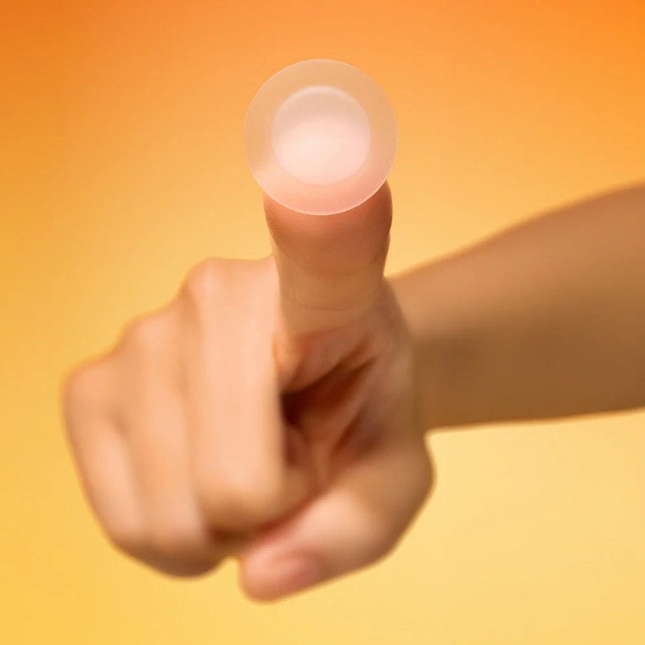 BY WISHTREND Mandelic Acid Spot Clearing Patch 39 Patches, main tenant un patch sur fond orange ensoleillé.