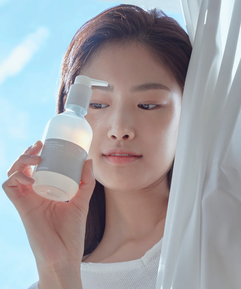 CELIMAX Dual Barrier Mild Gel Cleanser 200ml : femme tenant le flacon blanc, ambiance salle de bain, marque CELIMAX.
