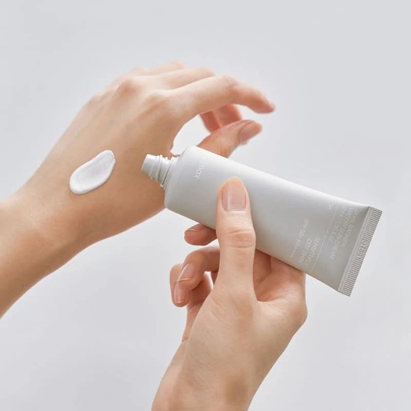 Main applique CELIMAX Dual Barrier Watery Sun Cream 40ml, crème solaire sur peau, fond clair
