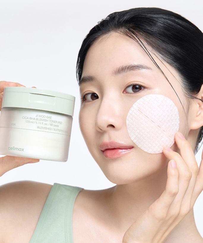 CELIMAX Ji Woo Gae Cica BHA Blemish Toner Pad 60 pads : femme applique un pad, marque CELIMAX, flacon à côté, fond clair.