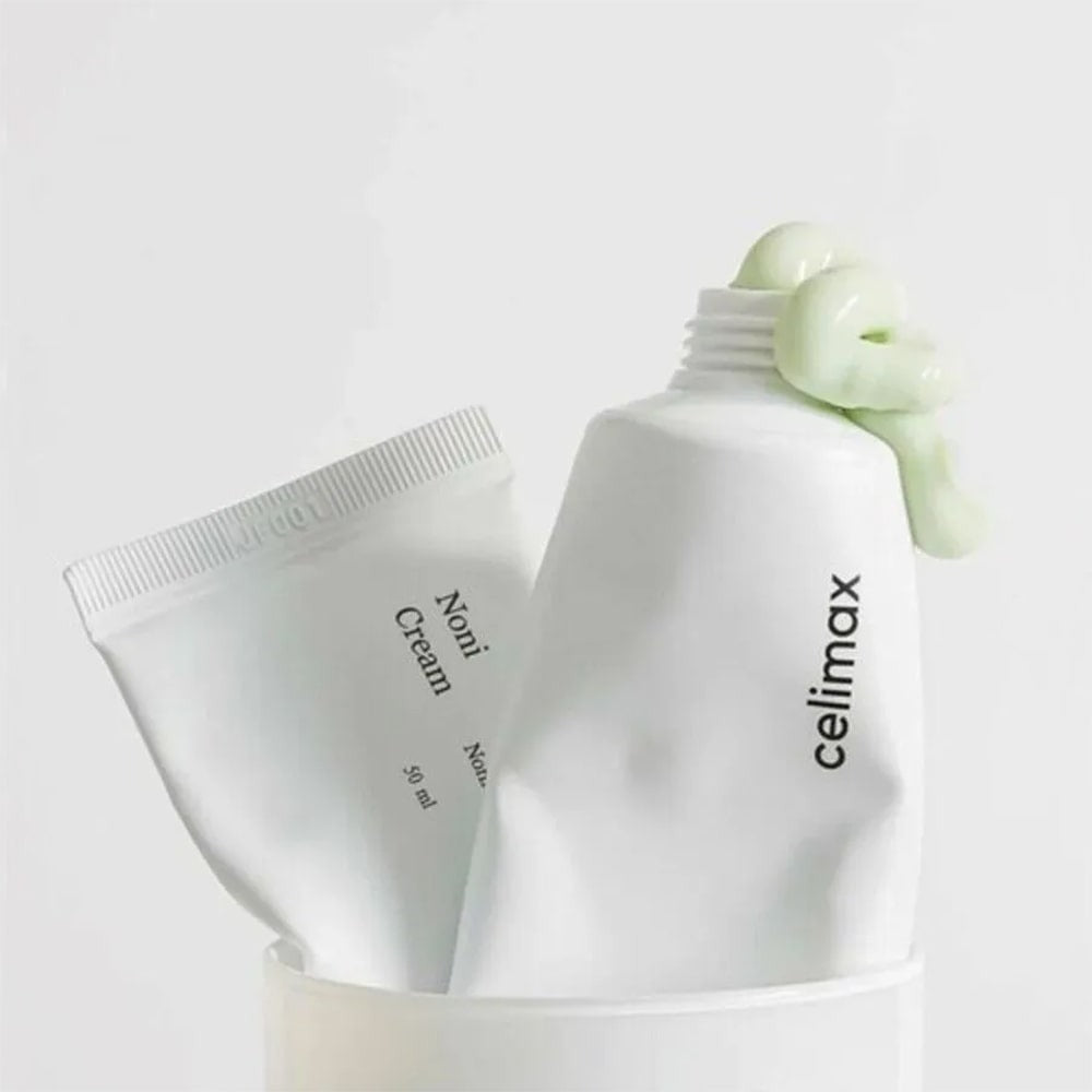 CELIMAX The Real Noni Energy Repair Cream 50ml, tube et pot sur fond clair avec feuilles de noni, marque CELIMAX