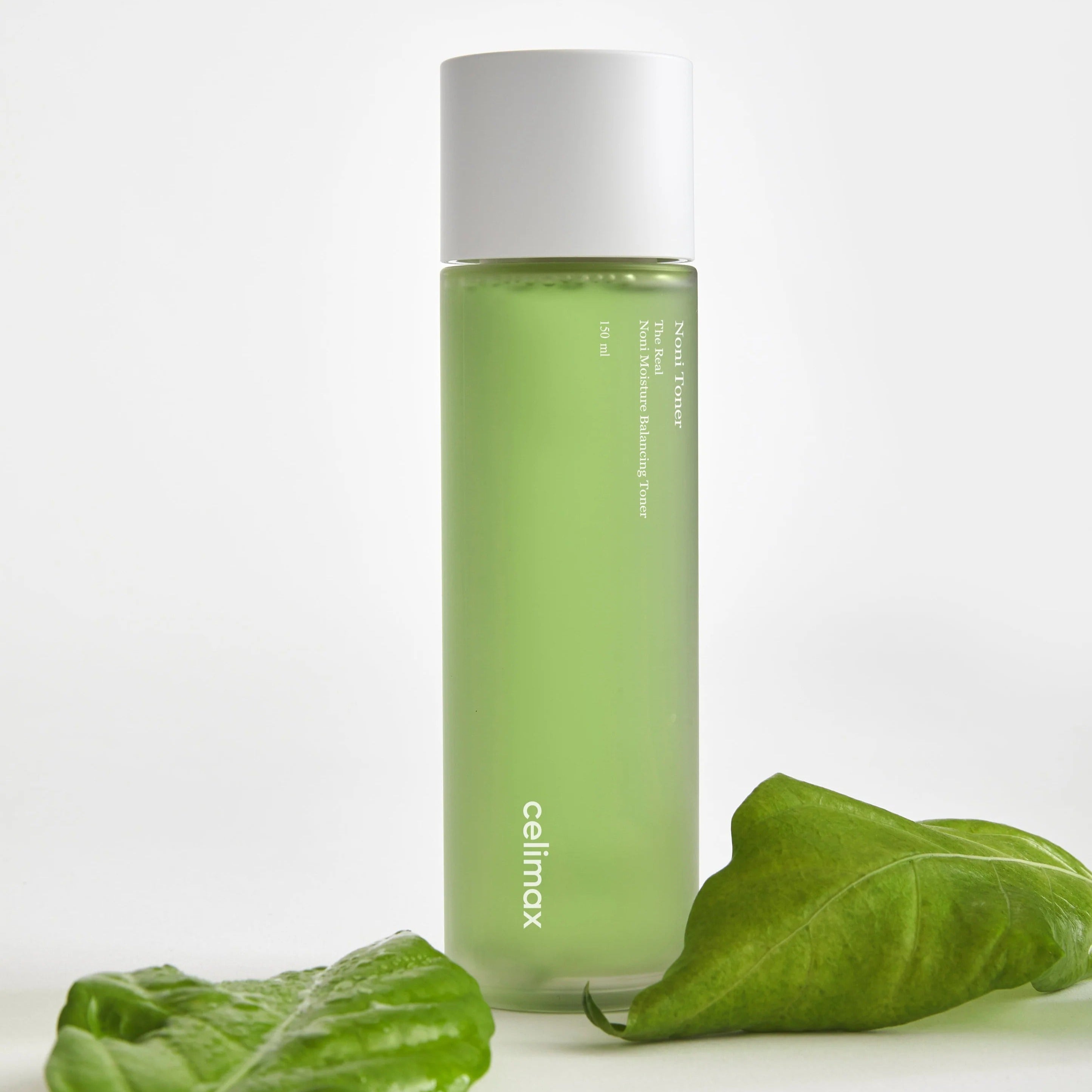 CELIMAX The Real Noni Moisture Balancing Toner 320ml sur fond blanc, marque et feuilles de noni, contexte visuel produit