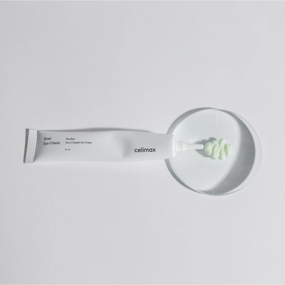 Décris l'image en français : CELIMAX The Real Noni Ultimate Eye Cream 20ml de marque celimax, tube blanc sur fond clair.