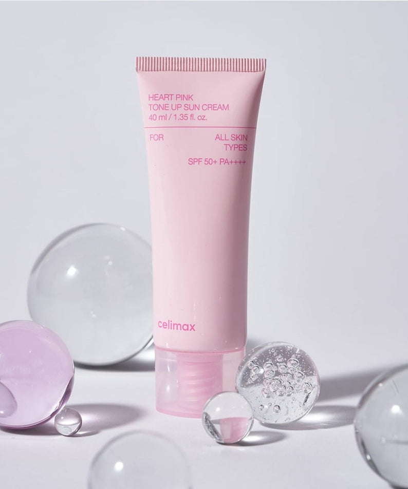 Crème solaire CELIMAX Heart Pink Tone-up Sun Cream 40ml avec SPF 50, présentée avec des sphères de verre sur fond blanc.