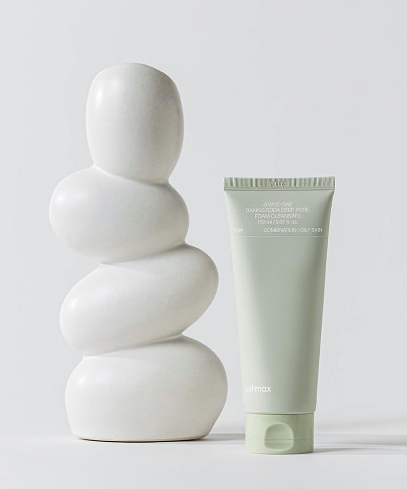 Tube de CELIMAX Ji Woo Gae Baking Soda Deep Pore Foam Cleansing 150ml à côté d'une sculpture moderne blanche.