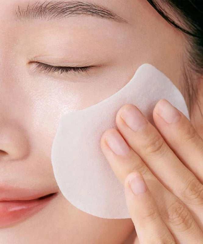 Femme utilisant CELIMAX Pore Dark Spot Brightening Pad 40ea pour améliorer l'éclat de la peau et réduire les taches. Soins beauté efficaces.