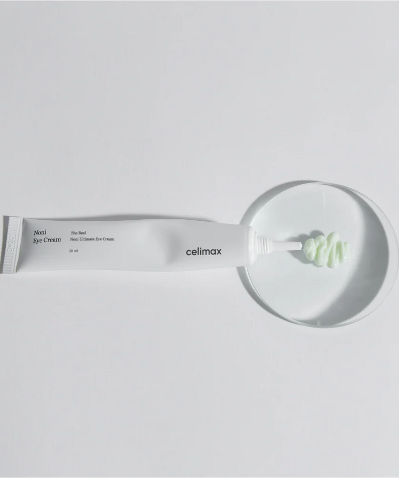 CELIMAX The Real Noni Ultimate Eye Cream 20ml sur une soucoupe blanche, crème verte, texture riche.