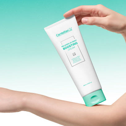 CENTELLIAN 24 Relaxing Up Body Boosting Cream 250ml, main tenant le tube sur fond turquoise, crème pour le corps.