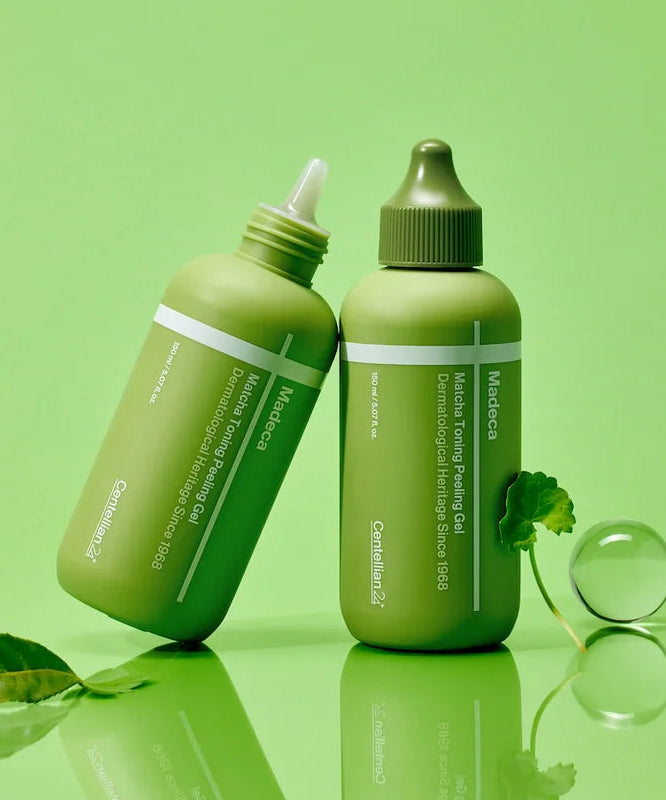 Deux flacons de CENTELLIAN 24 Madeca Matcha Toning Peeling Gel 150ml posés sur fond vert, avec une feuille à côté.