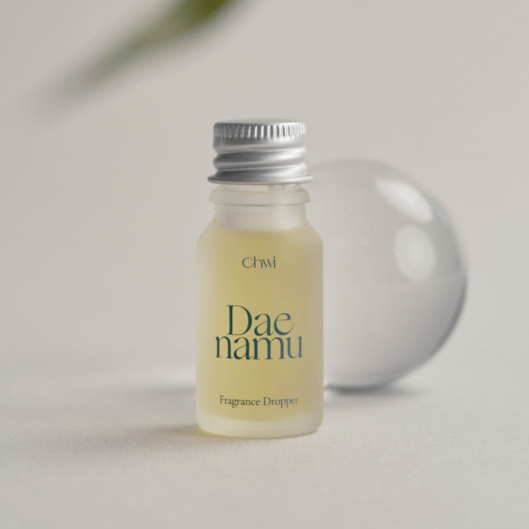 CHWI (CHI) Dae Namu Frangrance Dropper 10ml, bouteille goutte à goutte CHWI sur fond beige, lumière naturelle.
