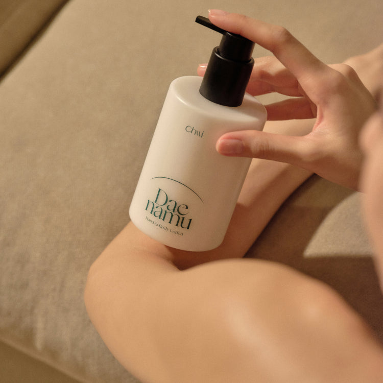 CHWI (CHI) Dae Namu Hand & Body Lotion 300ml, flacon sur peau, mains appliquant la lotion en contexte spa.