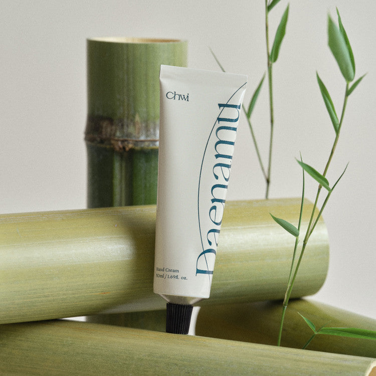 CHWI (CHI) Dae Namu Hand Cream 50ml : tube crème blanche à côté de tiges de bambou, fond clair, marque CHI