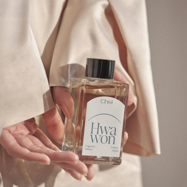 CHWI (CHI) Hwa Won Diffuser 100ml : bouteille tenue en main, tenue beige, ambiance élégante, marque CHiW en visuel