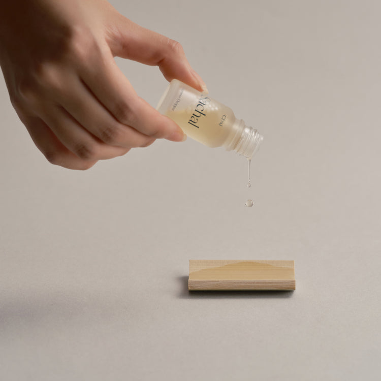 Main tenant CHWI (CHI) Sachak Fraangrance Dropper 10ml, gouttes sur fond beige, marque CHWI au visuel.