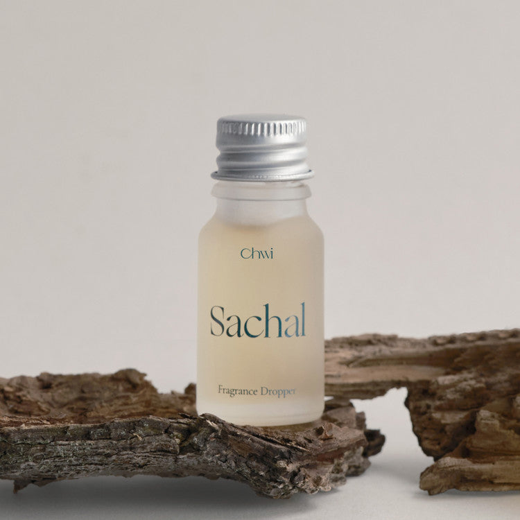 CHWI (CHI) Sachak Fraangrance Dropper 10ml de la marque CHWI, flacon au goutte-à-goutte sur bois, fond clair.