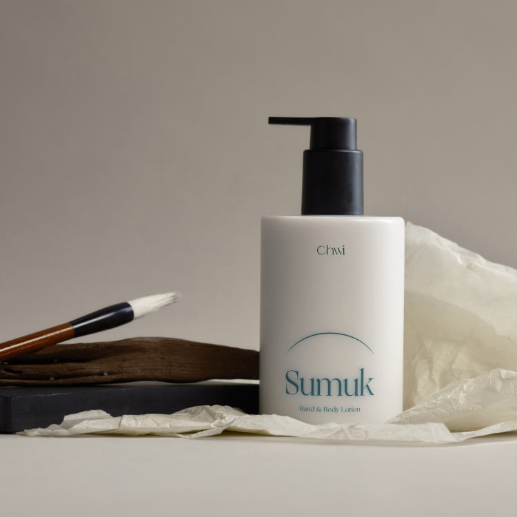 CHWI (CHI) Sumuk Hand & Body Lotion 300ml, photo produit CHWI sur papier crème et serviette blanche, pompon noir