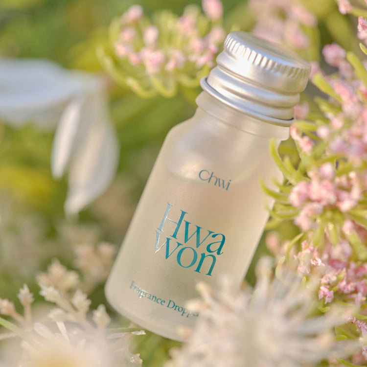 CHWI (CHI) Wha Won Fragrance Dropper 10ml, bouteille en verre près de fleurs roses, marque CHWI (CHI), jardin.