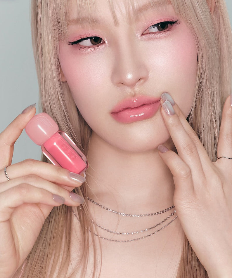 CLIO Volume Mate Blur Tint/Gloss en utilisation par un modèle. Cosmétique pour lèvres offrant brillance et volume. Produit beauté élégant.