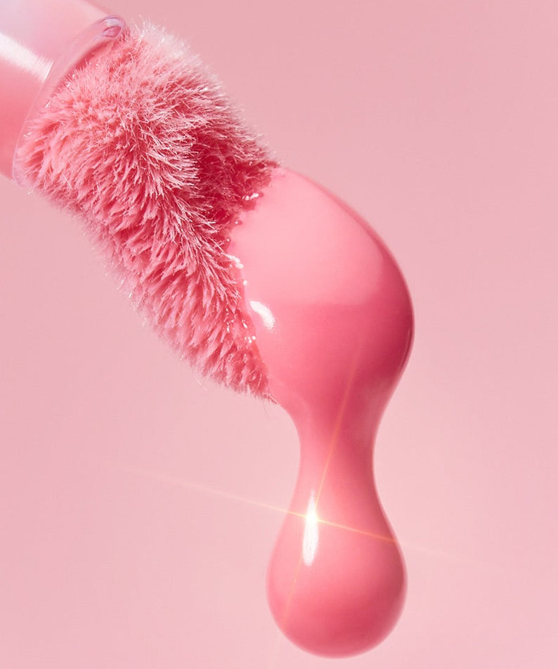 CLIO Volume Mate Blur Tint/Gloss - applicateur rose brillant avec texture crémeuse et éclatante sur fond rose. Maquillage tendance.