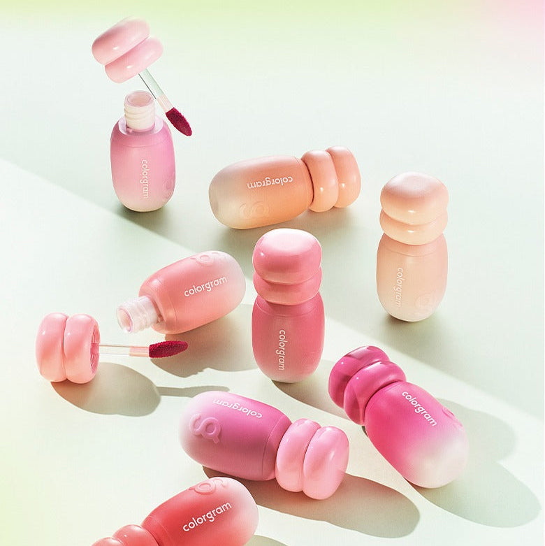 COLORGRAM Juicy Jam Blur Tint 5g de la marque COLORGRAM : tubes roses sur fond clair, ambiance maquillage pastel.