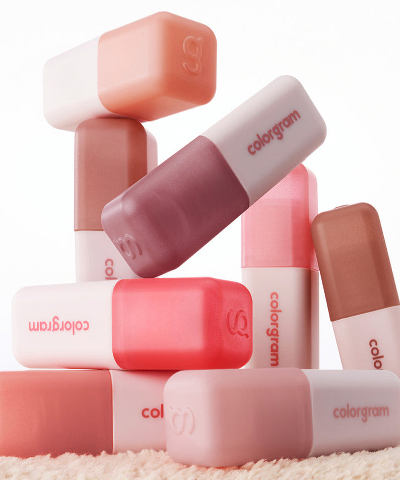 Collection de produits COLORGRAM Nude Blur Tint sur fond blanc, tubes empilés élégamment pour un effet de flou nuancé.