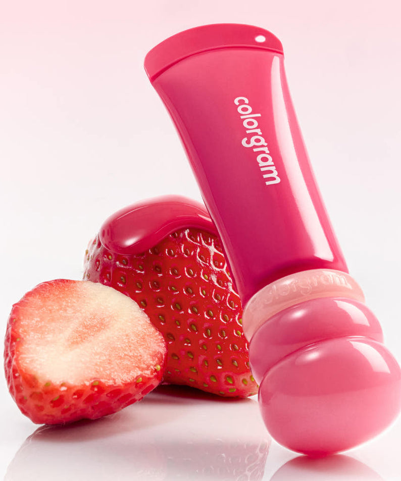 Décris l'image en français: COLORGRAM Tanghulu Lip Serum 9g, marque COLORGRAM, flacon rose sur fraises en studio.