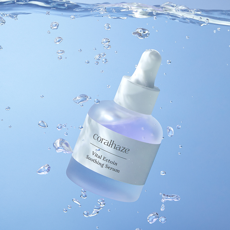 CORALHAZE Vital Ection Soothing Serum 30ml, flacon dans des gouttes d’eau sur fond bleu, ambiance apaisante.