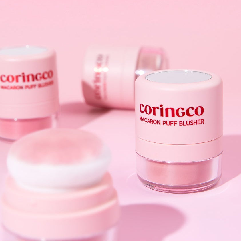 CORINGCO Macaron Puff Blusher de la marque CORINGCO, packaging rose sur fond pastel, produit maquillage en gros plan.
