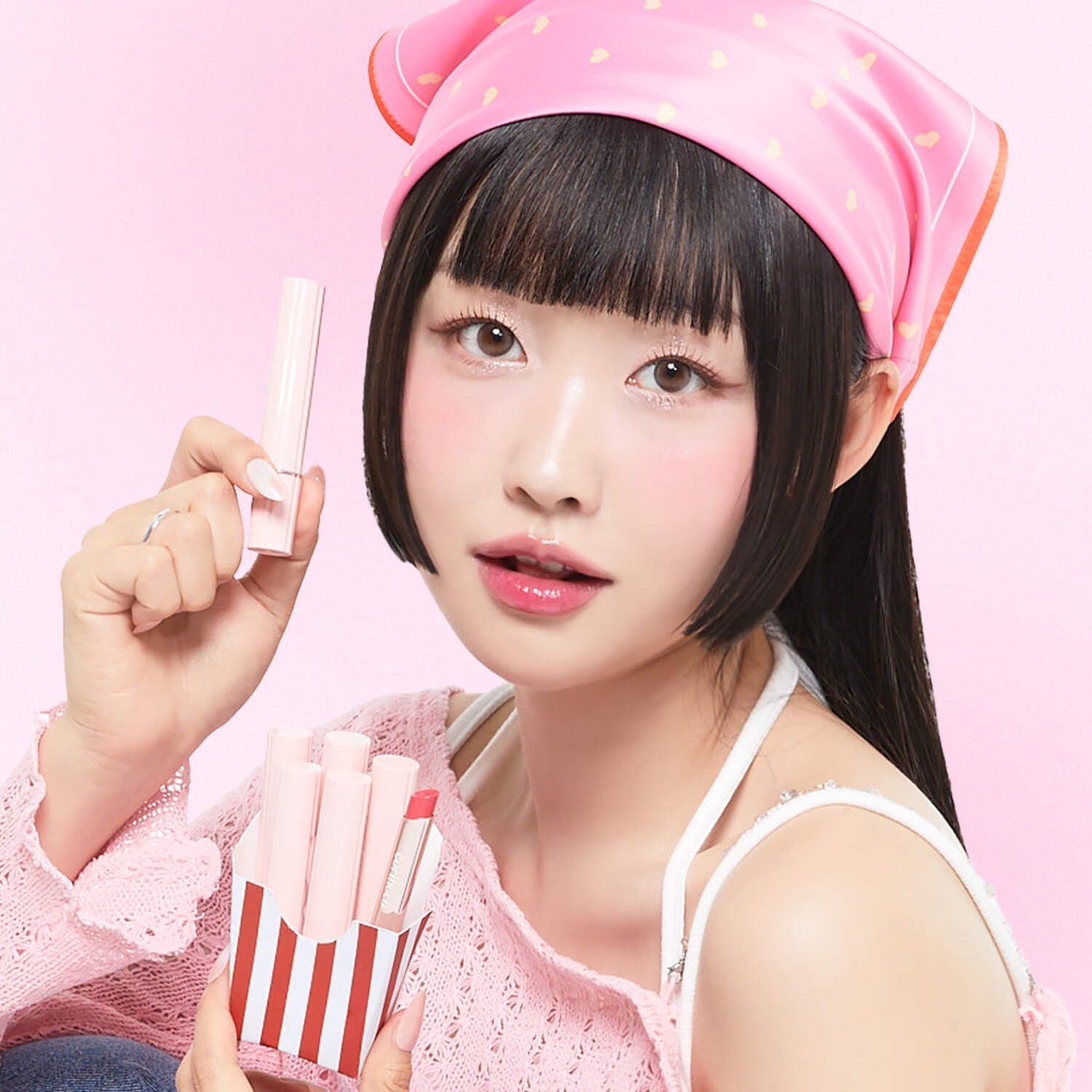 Décris l'image en français : CORINGCO Pink Churrons Plumping Glossy Lip, marque CORINGCO, lèvres brillantes, modèle sur fond rose.