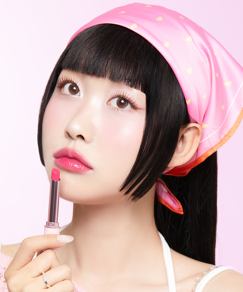 CORINGCO Pink Churrons Plumping Glossy Lip, la marque sur un gloss rose luisant, maquillage sur fond rose pastel, portrait