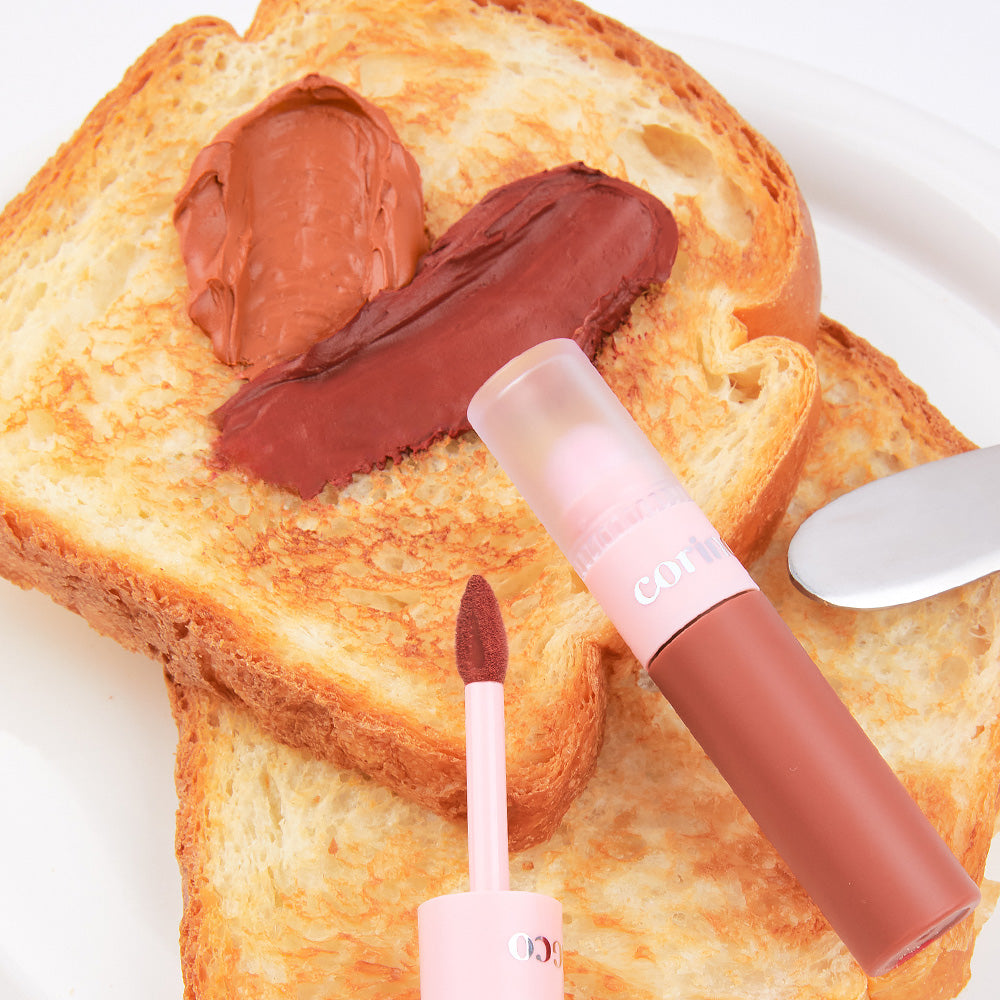 CORINGCO Topping Tip Velvet Lip Tint : tube et applicateur sur pain grillé, crème chocolatée, visuel gourmand, marque CORINGCO.