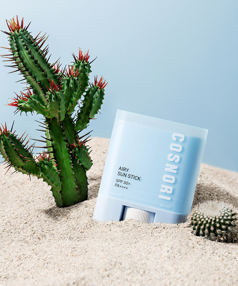 COSNORI Airy Sun Stick 20.5g (SPF50+ PA++++) sur sable et cactus, visuel soleil plage, marque COSNORI